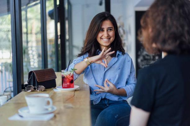 Two women smiling and speaking in sign language